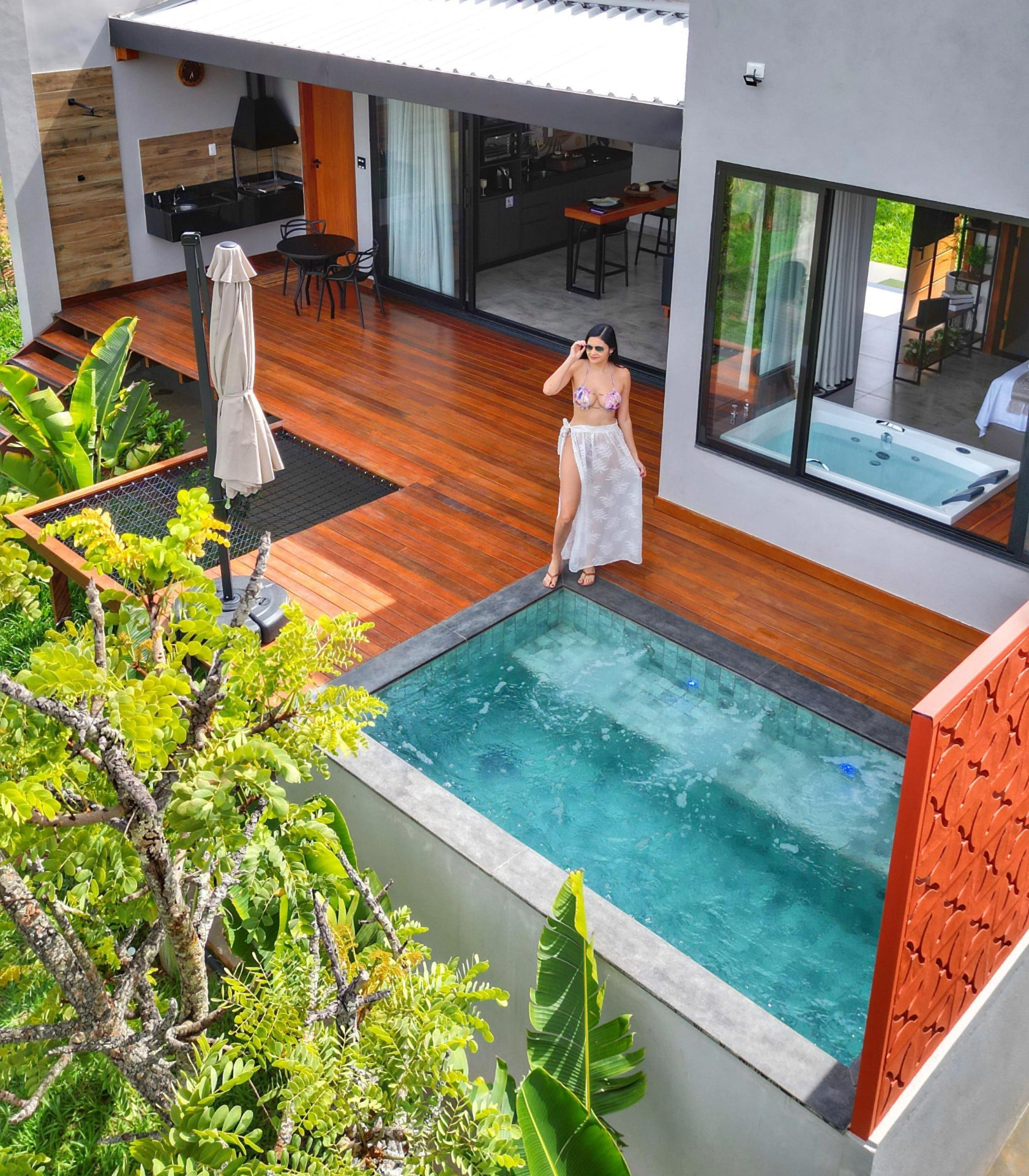 Vista elevada do loft, da piscina e da área externa cercada pela natureza