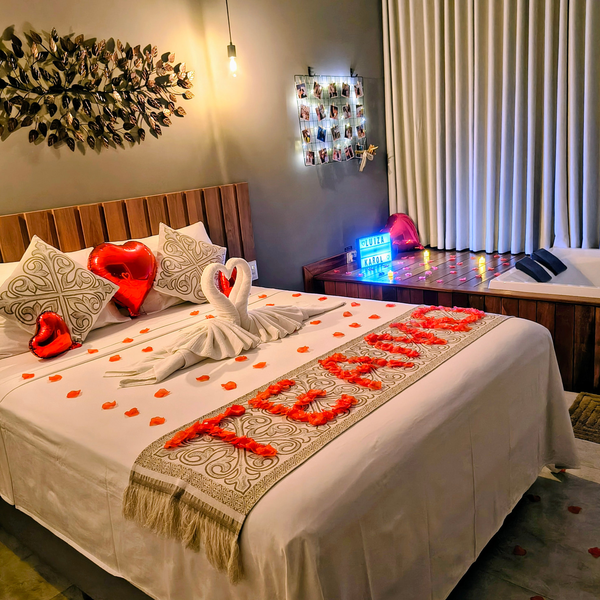 Cama climatizada preparada com pétalas, toalhas em formato de cisnes e jacuzzi ao lado